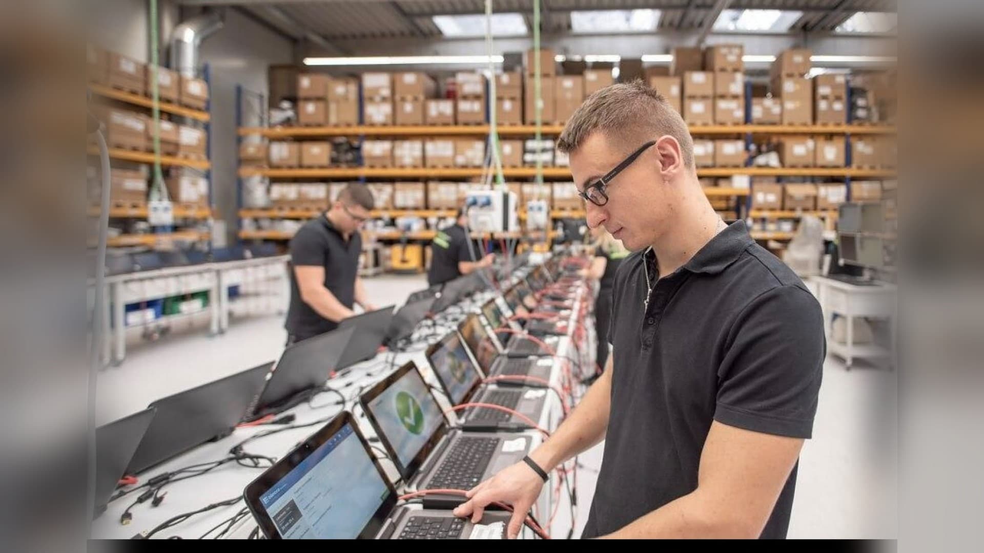 Bancada de preparação da Brain com a equipe testando e configurando notebooks antes da entrega